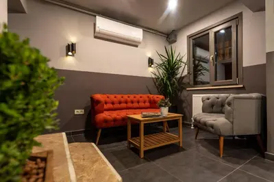 a waiting room with an orange couch and two chairs at Bram Hotel Istanbul in Istanbul