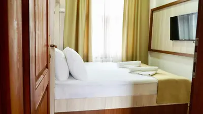 a bedroom with a white bed and a window at QONAQ HOTEL & SUITES in Istanbul