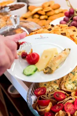 a plate of food with cheese and vegetables on a table at Levent Lavandula Hotel in Istanbul