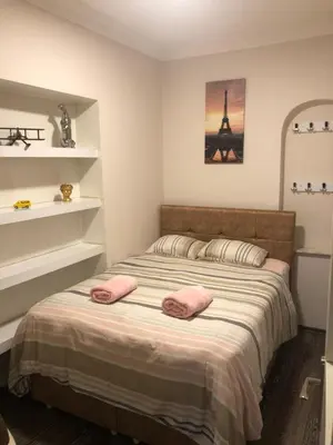 a bedroom with a bed with two pink pillows on it at İskete Suit in Istanbul