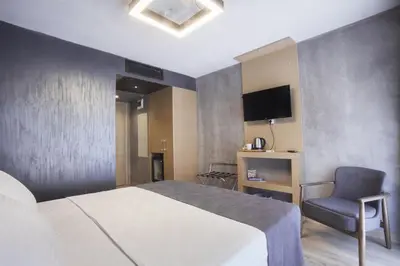 a bedroom with a bed and a chair and a television at Red Stone Hotel in Istanbul
