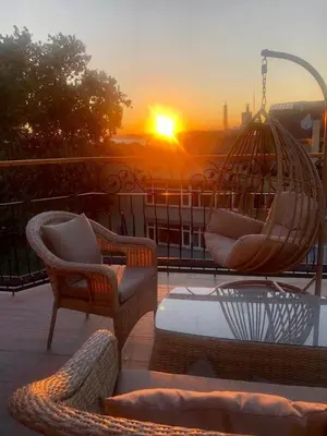 a patio with chairs and a swing with the sunset at Red Stone Hotel in Istanbul