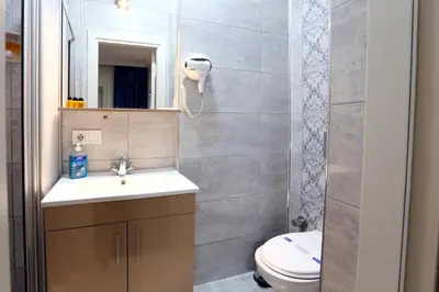 a bathroom with a sink and a toilet and a mirror at Taksim ABC Hotel in Istanbul