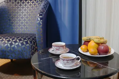 a table with two cups of coffee and fruit on it at Taksim ABC Hotel in Istanbul