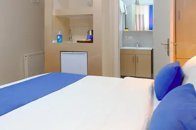 a bedroom with a white bed with blue pillows at Taksim ABC Hotel in Istanbul