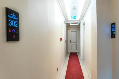 a hallway with a red carpet and a clock on the wall at City Hall Hotel Sultanahmet in Istanbul