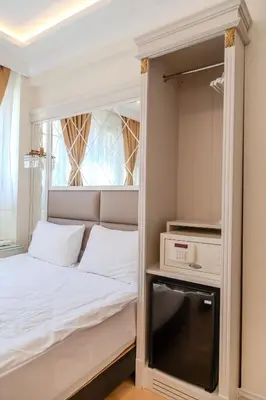 a small bedroom with a bed and a tv at City Hall Hotel Sultanahmet in Istanbul