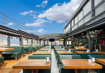 a restaurant with wooden tables and green chairs at Sanat Hostel Taksim in Istanbul
