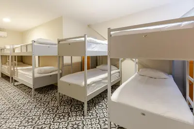 a room with three bunk beds and a tile floor at Sanat Hostel Taksim in Istanbul