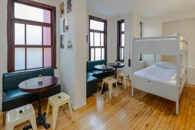 a small room with a bunk bed and a table and chairs at Sanat Hostel Taksim in Istanbul