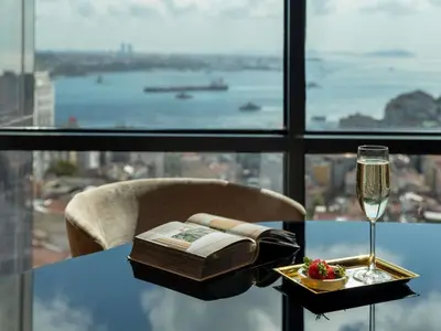 a table with a book and a glass of wine at Sofitel Istanbul Taksim in Istanbul