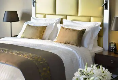 a bedroom with a large bed with white sheets and pillows at Wyndham Grand Istanbul Europe in Istanbul