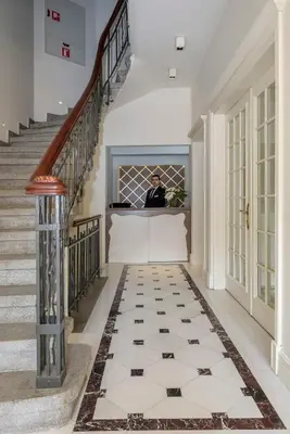 a man in a suit standing at a counter in a hallway with stairs at Stay Lab Taksim 15 Suites in Istanbul