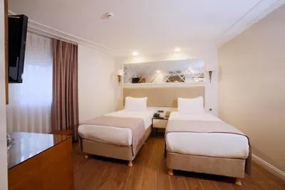 a hotel room with two beds and a television at SORRISO HOTEL DUE in Istanbul
