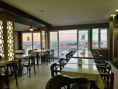 a restaurant with tables and chairs and windows at Elit Palace Hotel in Istanbul