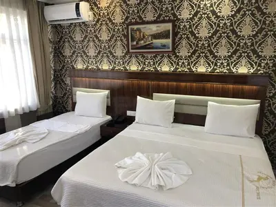 two beds with white sheets in a hotel room at Elit Palace Hotel in Istanbul