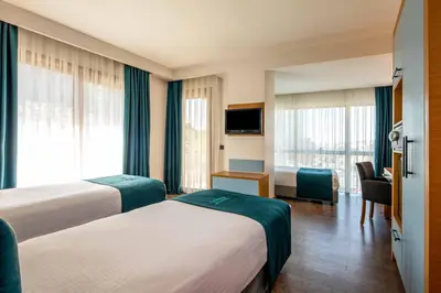 a hotel room with two beds and a television at Urban Hotel Bomonti in Istanbul