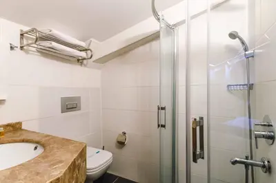 a bathroom with a shower and a sink and a toilet at Urban Hotel Bomonti in Istanbul