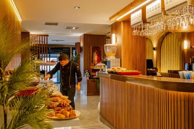 a man standing at a buffet in a restaurant at Frt Airlines Hotel - Istanbul Airport in Arnavutköy