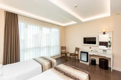 a hotel room with a bed and a desk and a tv at Morava Hotel in Istanbul