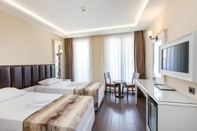 a hotel room with two beds and a television at Morava Hotel in Istanbul