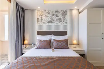 a bedroom with a bed with two tables and two lamps at MENAR HOTEL&SUITES -Old City Sultanahmet in Istanbul