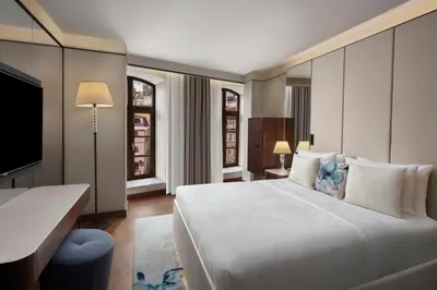 a bedroom with a large white bed and a desk at JW Marriott Istanbul Bosphorus in Istanbul
