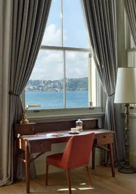 a desk and a chair in front of a window at Kocatas Mansions in Istanbul
