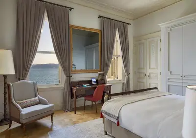 a bedroom with a bed and a desk and a mirror at Kocatas Mansions in Istanbul