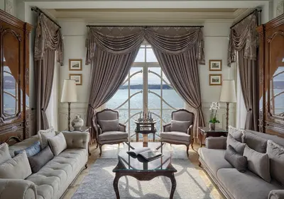 a living room with a couch and a large window at Kocatas Mansions in Istanbul