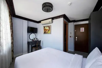 a bedroom with a white bed and a blue wall at Mytra Hotel in Istanbul