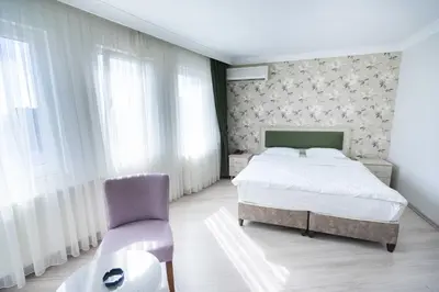 a bedroom with a bed and a chair and a table at Hotel Libiza in Gebze