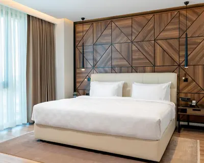 a bedroom with a large white bed with a wooden headboard at Radisson Blu Hotel, Sakarya in Sakarya