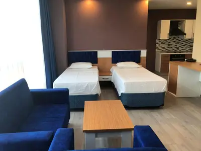 a hotel room with two beds and a couch at SKYBLUE İSTANBUL HOTEL in Istanbul