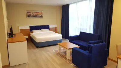 a bedroom with a bed and a couch and a chair at SKYBLUE İSTANBUL HOTEL in Istanbul
