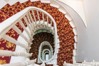 a spiral staircase in a building with red and gold carpet at Punto Suite in Istanbul