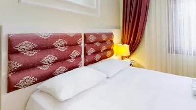 a bedroom with a white bed and a red curtain at The Wolf Hotel in Istanbul