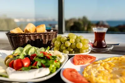a table with plates of food and a basket of fruit at The Camelot Hotel in Istanbul