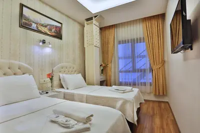 a hotel room with two beds and a window at Gh Suites Taxim Hotel in Istanbul