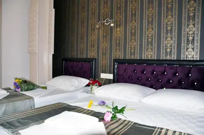 two beds with white pillows and a purple headboard at Gh Suites Taxim Hotel in Istanbul