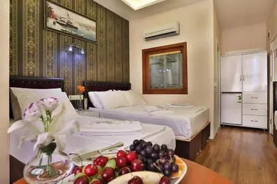 a hotel room with two beds and a table with a plate of fruit at Gh Suites Taxim Hotel in Istanbul