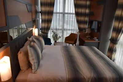 a bedroom with a large bed with a large window at Grand Rimedya Hotel Bursa in Panayır