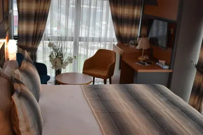 a bedroom with a bed and a desk and a chair at Grand Rimedya Hotel Bursa in Panayır
