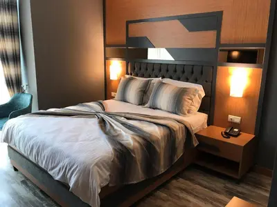 a bedroom with a large bed with a headboard at Grand Rimedya Hotel Bursa in Panayır