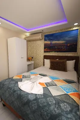 a bedroom with a bed with a large painting on the wall at HamzaBey Hotel in Istanbul