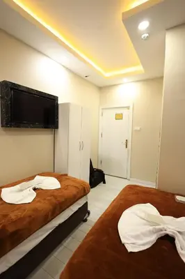 a hotel room with two beds and a flat screen tv at HamzaBey Hotel in Istanbul