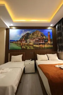 two beds in a room with a painting on the wall at HamzaBey Hotel in Istanbul