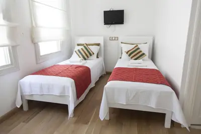 two beds in a room with white walls and windows at Pi Art Butik Otel in Istanbul