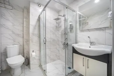 a bathroom with a toilet and a sink and a shower at Bakırköy Zeugma Suit Otel in Istanbul