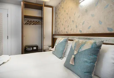 a bedroom with a white bed with blue pillows at Lika Hotel in Istanbul